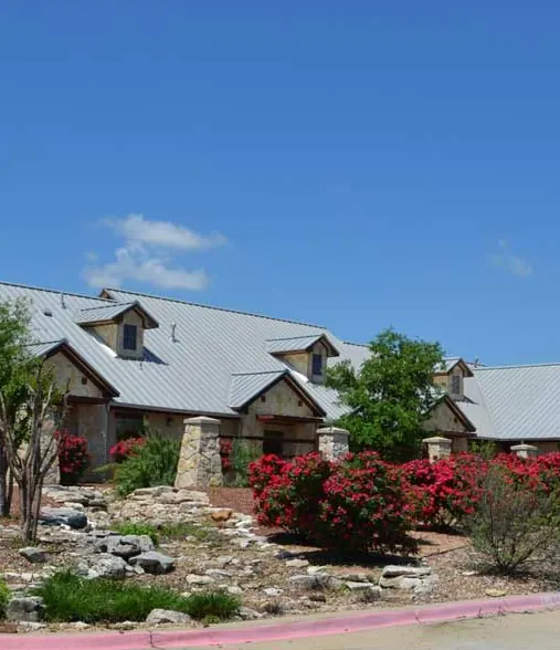 The courtyard and back of the building, with Hill Country landscaping and flowering shrubs.